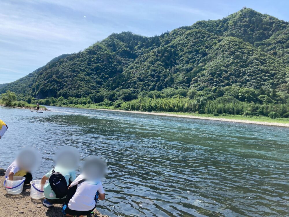 金華山と長良川を背に鮎の放流